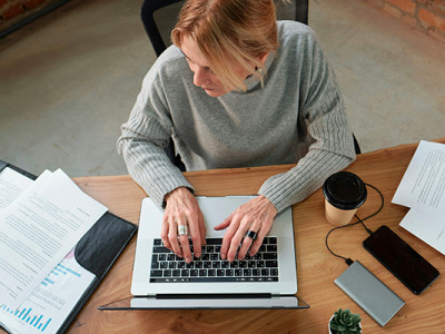 Femme consultant des documents sur l’ordinateur pour racheter une assurance vie