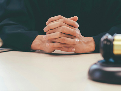 Magistrat assis les mains croisées, évoquant une procédure judiciaire de blocage d’héritage