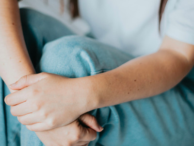 Femme assise tenant son ventre, illustration de douleurs liées à une descente d’organe