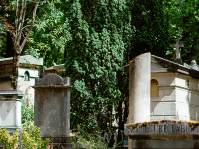 Sépultures anciennes et croix en pierre dans un cimetière arboré