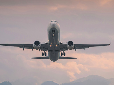 Avion en vol au-dessus des nuages après annulation d’un billet suite à un décès