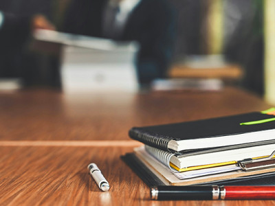 Dossiers de succession posés sur une table lors d’un rendez-vous chez le notaire après un décès