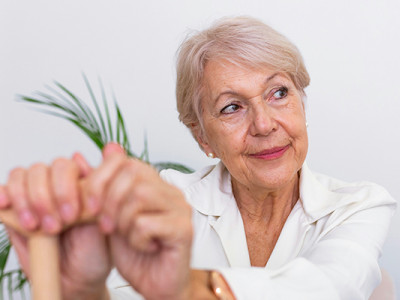 Femme âgée souriante, vivant avec la maladie de Parkinson