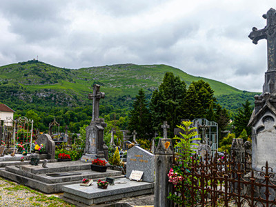 Cimetière traditionnel avec tombes en pierre et croix, situé en montagne