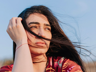Jeune femme pensive regardant au loin en pleine nature, traversant une période de deuil