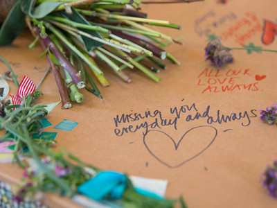 Message d’adieu et fleurs sur un cercueil en carton personnalisé lors de funérailles