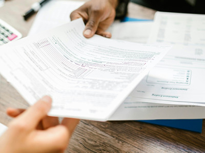 Documents d’assurance vie à remplir après un décès, posés sur une table avec une calculatrice