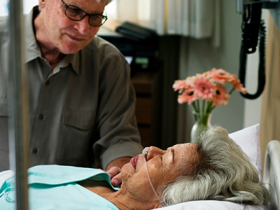 Homme au chevet d'une personne en fin de vie à l’hôpital, illustration du métier de thanatopracteur