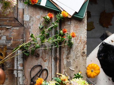 Bouquet de fleurs, citrouilles et objets symboliques pour honorer un défunt à la Toussaint
