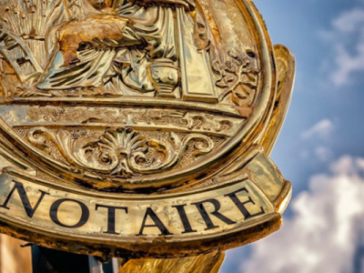 Plaque dorée d’une étude notariale en façade, symbolisant la recherche d’un notaire après un décès
