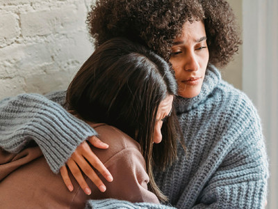 Deux femmes en deuil se réconfortent dans une étreinte chaleureuse après un décès