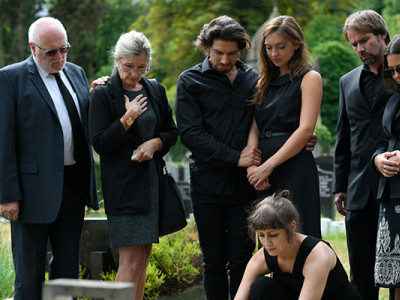 Famille habillée en noir lors d’un enterrement dans un cimetière