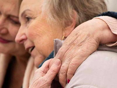 Deux femmes âgées se soutiennent dans un moment de tendresse et d'écoute en fin de vie